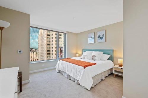 um quarto com uma cama grande e uma janela grande em Sparkling 2BR / 2BA in Back Bay em Boston