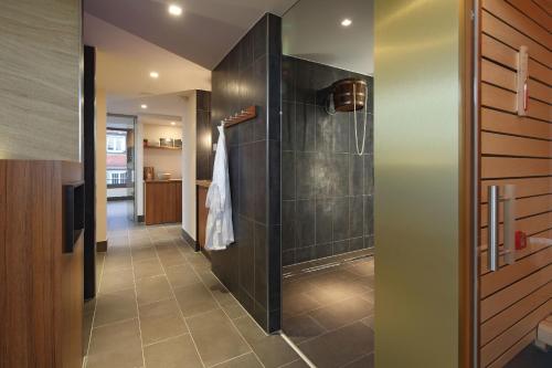 a bathroom with a walk in shower next to a glass door at Hotel Krone ****S in Tübingen