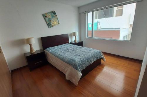 1 dormitorio con cama y ventana grande en Hermoso departamento en la mejor zona de Quito, en Quito