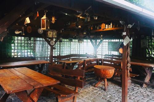 restauracja z drewnianymi stołami, krzesłami i oknami w obiekcie Wrzosówka w Jeleniej Górze