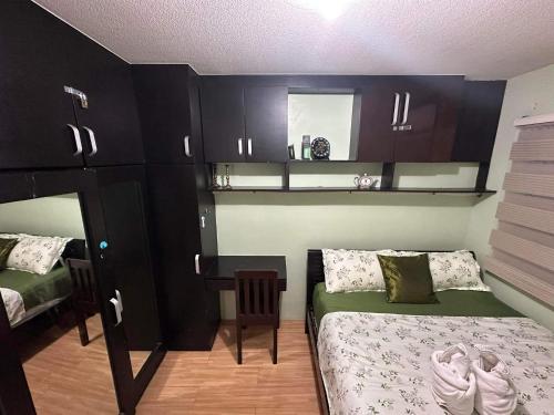 a bedroom with black cabinets and a bed and a mirror at Ri's One Oasis w Free Pool back of SM City Mall in Davao City