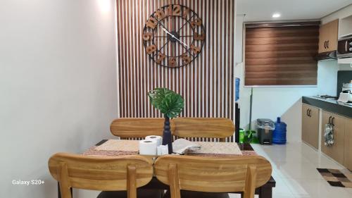 a table with two chairs and a clock on the wall at Ri's One Oasis w Free Pool back of SM City Mall in Davao City