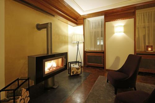 a living room with a fireplace and a chair at Hotel Krone ****S in Tübingen