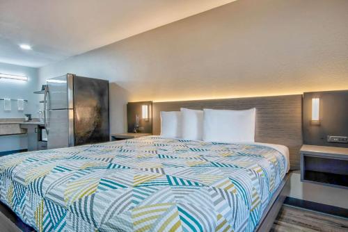 a hotel room with a bed and a kitchen at Studio 6 - Texas City, TX in Texas City