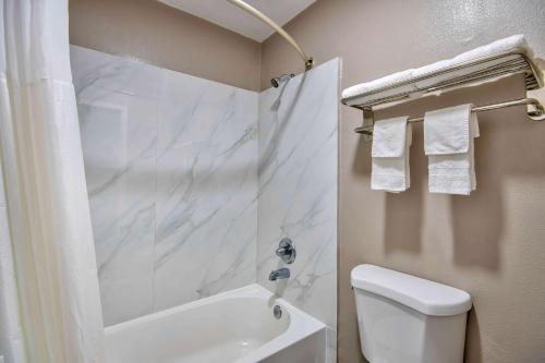 a white bathroom with a shower and a toilet at Studio 6 - Texas City, TX in Texas City