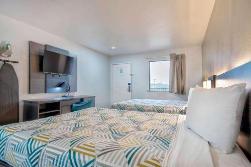 a hotel room with a bed and a television at Studio 6 - Texas City, TX in Texas City