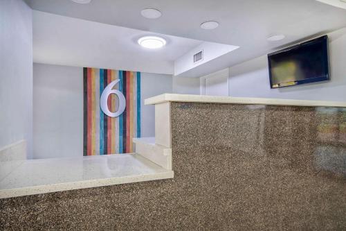 a lobby with a television and a wall with a carpet at Studio 6 - Texas City, TX in Texas City