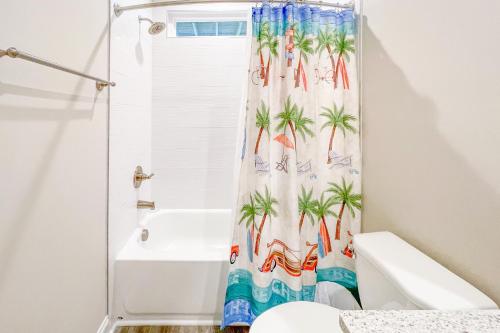 een badkamer met een douchegordijn met palmbomen bij Villas View in North Topsail Beach