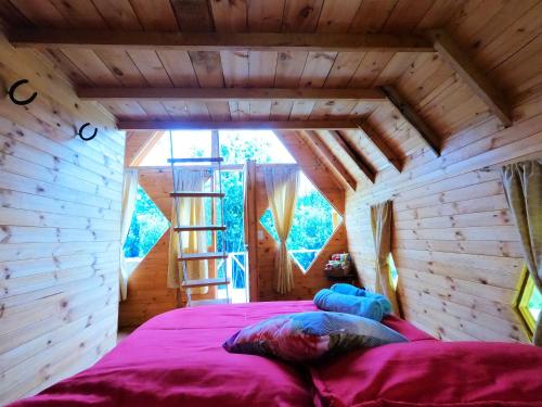 um quarto com uma cama numa casa de madeira em Glamping las 4 estaciones em Guatavita