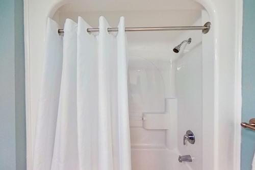 La salle de bains est pourvue d'une douche avec un rideau de douche blanc. dans l'établissement Caravelle Resort #622, à Myrtle Beach
