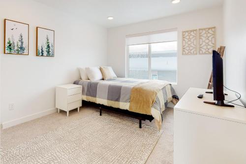 a bedroom with a bed and a desk with a television at Village Green Getaway in Park City
