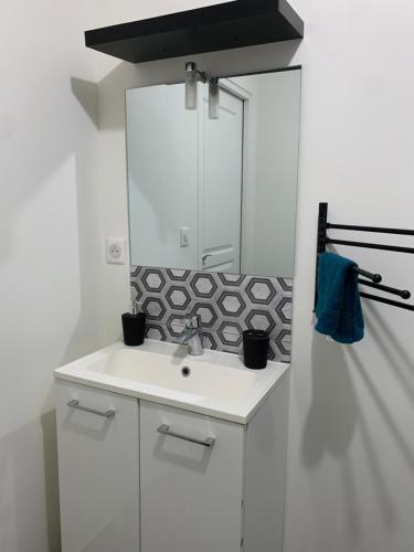 a white bathroom with a sink and a mirror at Appartement duplex proche zénith, mégacité, stade in Amiens