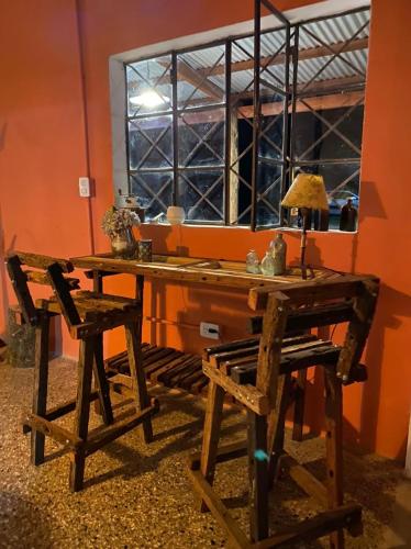 a wooden table and two chairs in front of a window at Inti, hospedaje de campo. in Bartolomé Mitre