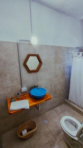 a bathroom with a blue sink and a toilet at Inti, hospedaje de campo. in Bartolomé Mitre