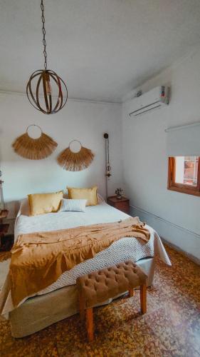 a bedroom with a large bed and a chandelier at Inti, hospedaje de campo. in Bartolomé Mitre