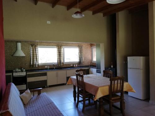 a kitchen with a table and chairs and a refrigerator at Casa de Montaña in Yacanto