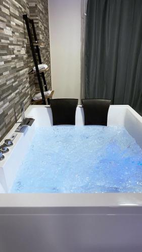 una vasca da bagno riempita con acqua blu in camera di Relax & Chill a Sevran