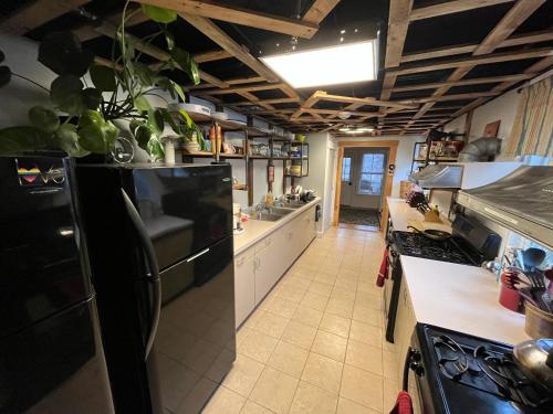 a kitchen with a black refrigerator and a counter top at CoHo: Conway Hostel in Conway