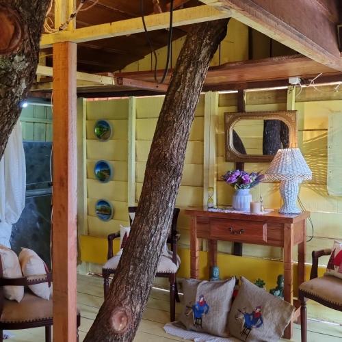 a room in a tree house with a table and chairs at A casa da arvore no Parana 