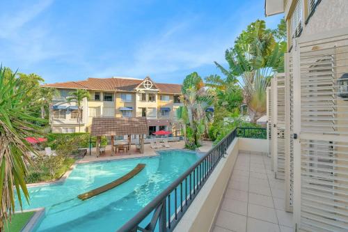 a balcony with a swimming pool and a house at The Lakes Resort Cairns in Cairns