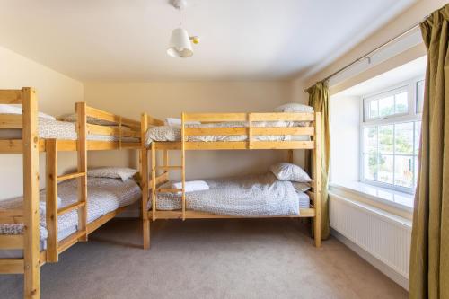 a bedroom with bunk beds in a room with a window at Bikehaus@The Colliers Arms in Abercanaid
