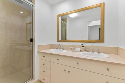 a bathroom with two sinks and a shower at The Lakes Resort Cairns in Cairns