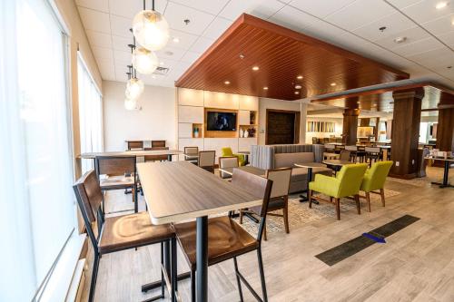 a restaurant with tables and chairs in a cafeteria at Holiday Inn Express & Suites Dayton East - Beavercreek by IHG in Beavercreek
