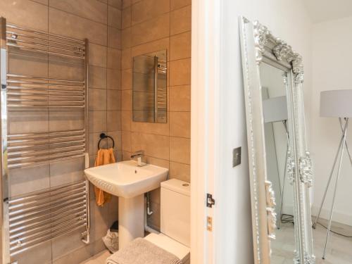 a bathroom with a sink and a shower and a mirror at Bryn Min Manton Bach in Caernarfon