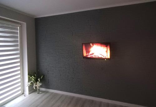 a black room with a fire in a window at WRN APARTAMENTY in Kalisz
