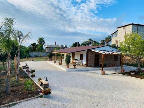 a house with a pavilion in the middle of a driveway at Chalet in campagna in Partanna