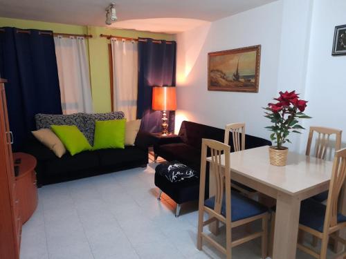 ein Wohnzimmer mit einem Sofa und einem Tisch in der Unterkunft Apartamento en el centro de zaragoza "EL RUBÍ DEL PILAR" in Saragossa