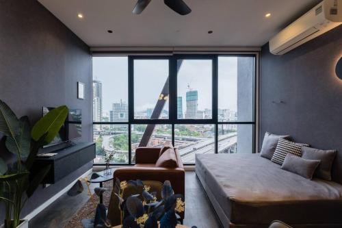 een woonkamer met een bank en een groot raam bij KLCC MusicalSty5Pax AT ScarletzSuites in Kuala Lumpur