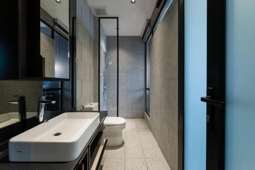 een badkamer met een witte wastafel en een toilet bij KLCC MusicalSty5Pax AT ScarletzSuites in Kuala Lumpur