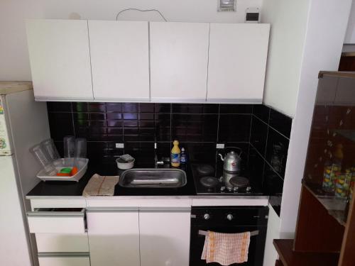 una piccola cucina con lavandino e piano cottura di Departamento para 4 personas en ezeiza a Ezeiza