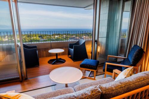 a balcony with furniture and a view of the ocean at KAMENOI HOTEL Izukogen in Ito
