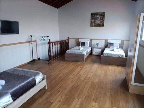 a room with three beds in a room with wooden floors at Azores House in Ponta Delgada