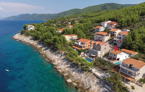 a group of houses on a hill next to the water at Vila Dream 1st row to the sea in Prigradica