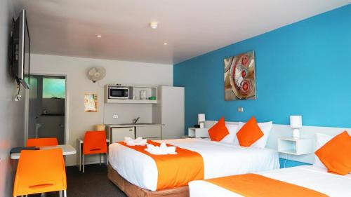 a hotel room with two beds and orange chairs at Waterfront Lodge Motel in Hobart