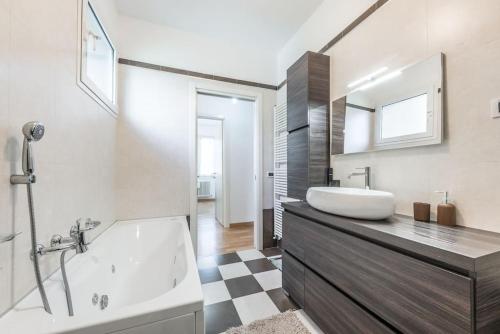 La salle de bains est pourvue d'une baignoire blanche et d'un lavabo. dans l'établissement Villa con giardino in piena città, à Modène
