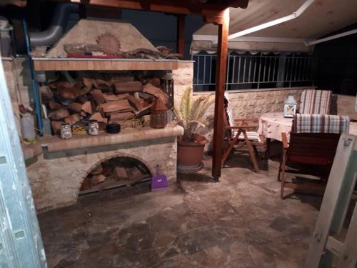 sala de estar con chimenea de piedra y mesa en Vicky's house en Mirina