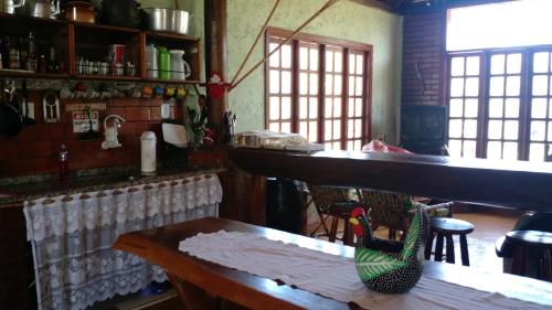 uma cozinha com um balcão, uma mesa e cadeiras em Pousada Sítio Rústicu's em Domingos Martins