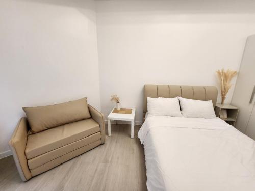 a bedroom with a bed and a chair at Minimalist Condo in Azure North in San Fernando