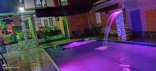einem Pool mit violetten Lichtern in einem Gebäude in der Unterkunft El Buen Sazon Valluno 