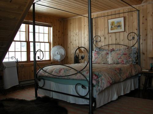 a bedroom with a bed with a metal canopy at Montana Spirit Guest Lodge in Cliff Lake