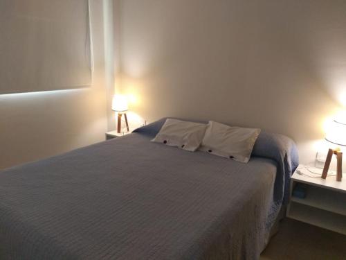 a bedroom with a bed with two tables and two lamps at Departamento macrocentro Santa Fe in Santa Fe