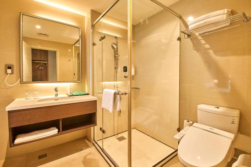 a bathroom with a shower and a toilet and a sink at The Fuli Resort Chihpen in Taitung City