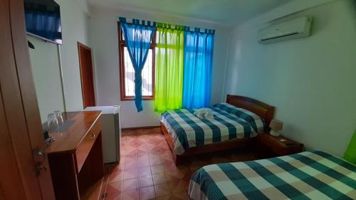 a hotel room with two beds and a window at El Paraiso in Puerto Ayora