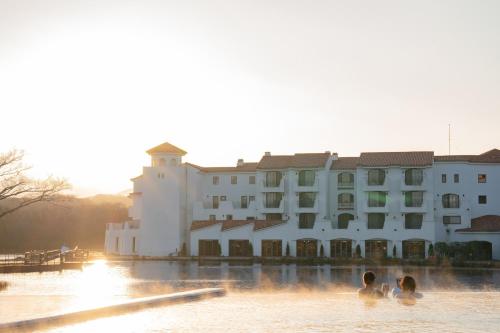 people swimming in the water in front of a building at Ecoland Hotel in Jeju