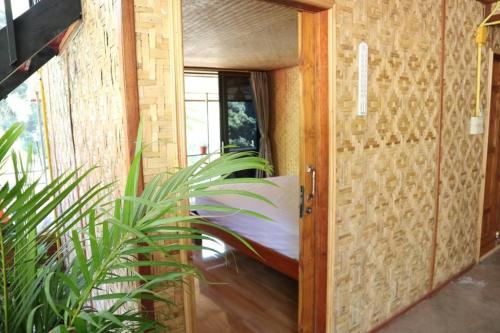 una puerta abierta a una habitación con una cama y una planta en โฮมสเตย์ เนเจอร์ เดอ สะปัน en Ban Huai Ti