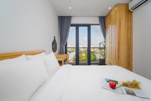 1 Schlafzimmer mit einem weißen Bett und einem Balkon in der Unterkunft Haphan Hotel And Apartment in Đà Nẵng